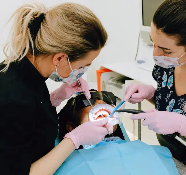 Two dental professionals working together on a patient.