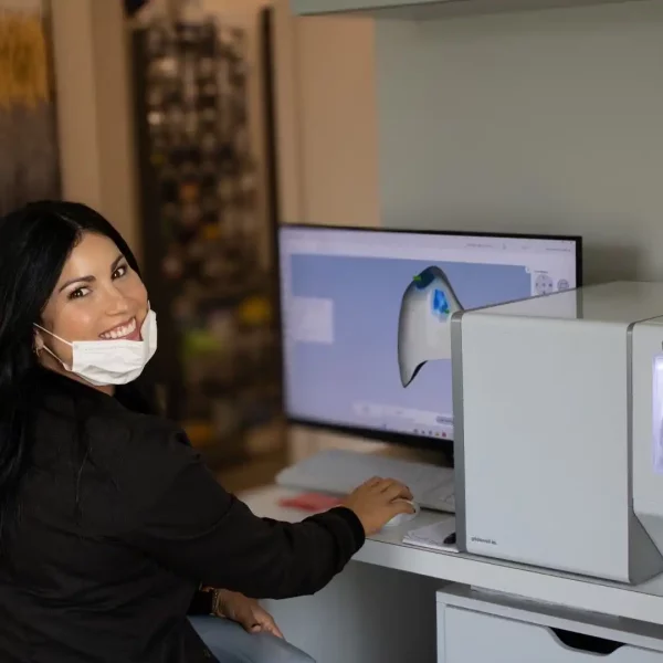 A dental professional looking at x-rays on a computer.