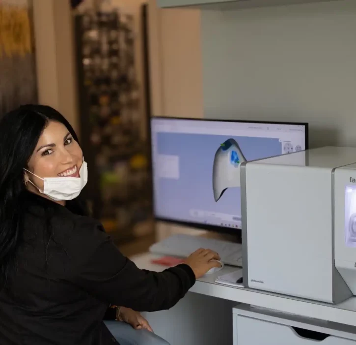 A dental professional looking at x-rays on a computer.