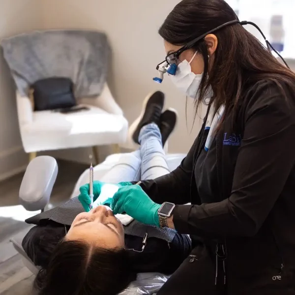 A dental professional working on a patient's mouth.