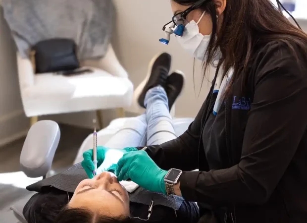 A dental professional working on a patient's mouth.